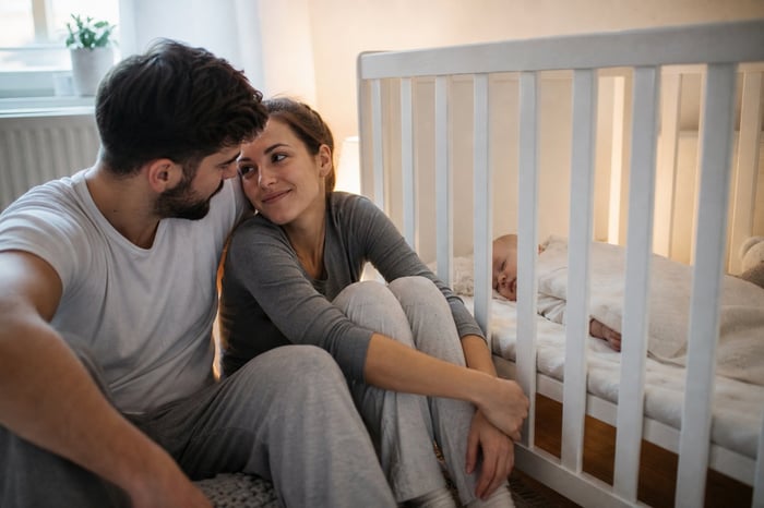 Young couple beside crib